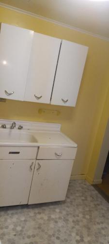 uma cozinha com armários brancos e um lavatório em Convenient with a view of downtown em Calumet