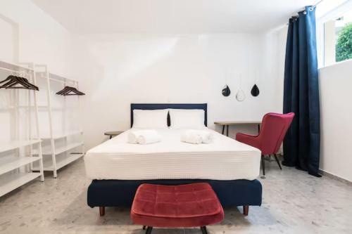 - une chambre avec un lit, une chaise rouge et un bureau dans l'établissement Panathinea, à Athènes