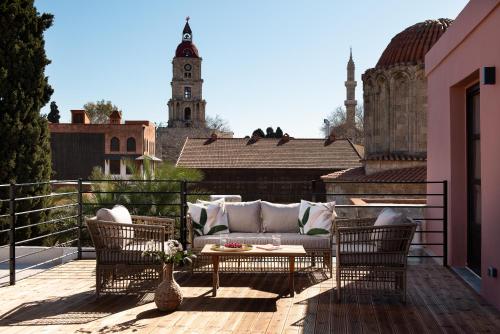 a patio with a couch and chairs on a balcony at Fluvian Terrace in Rhodes Town