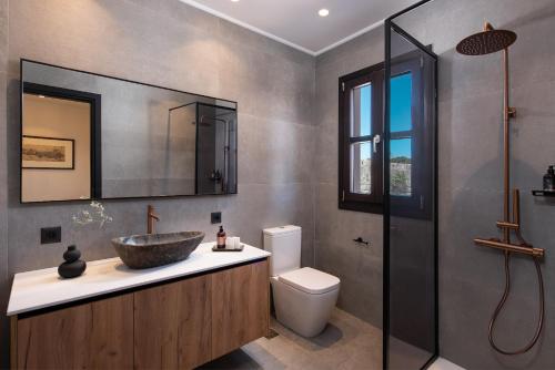 a bathroom with a sink and a toilet and a mirror at Fluvian Terrace in Rhodes Town