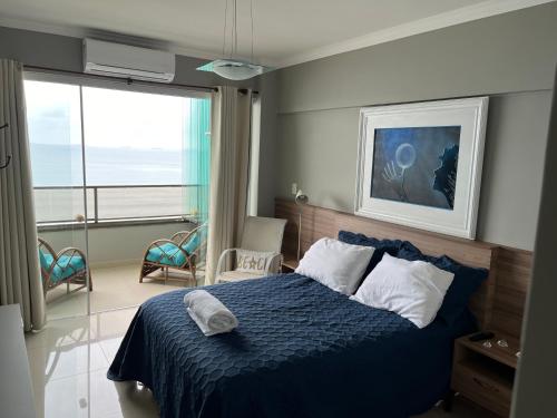 1 dormitorio con 1 cama con edredón azul en Guaruja Praia de Pitangueiras frente ao mar, en Guarujá