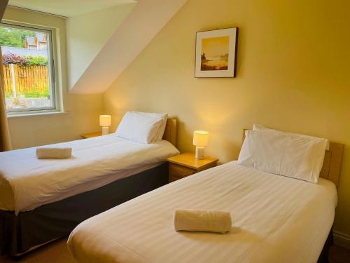 two beds in a small room with a window at 3 bedroomed house with view of Kenmare Bay Estuary in Kenmare