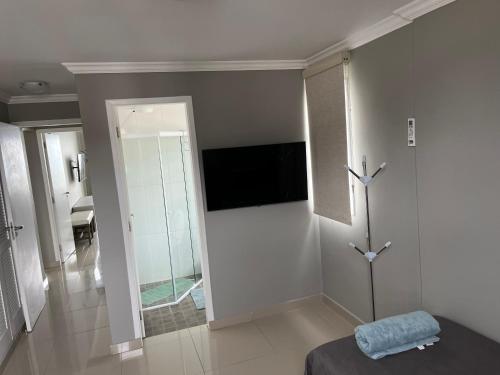 a bedroom with a mirror and a room with a bed at Guaruja Praia de Pitangueiras frente ao mar in Guarujá