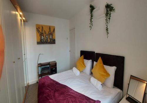 1 dormitorio con 1 cama con almohadas amarillas y blancas en Coventry 59 Michaelmas Pet Friendly 2 Bedroom Apt with Parking en Parkside