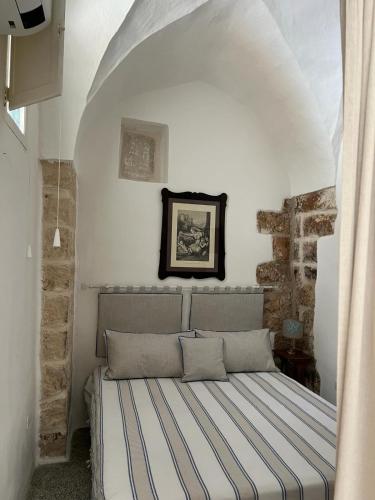 een slaapkamer met een bed in een witte kamer bij Dimora Lucrezia - A in Corigliano dʼOtranto