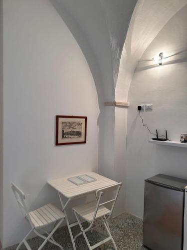 een witte tafel en 2 stoelen in een kamer bij Dimora Lucrezia - A in Corigliano dʼOtranto