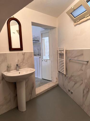 een badkamer met een wastafel, een douche en een spiegel bij Dimora Lucrezia - A in Corigliano dʼOtranto
