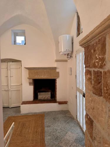 een woonkamer met een open haard en een stenen muur bij Dimora Lucrezia - A in Corigliano dʼOtranto