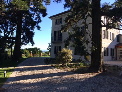 a road leading to a white house with trees at Casa Rita, Charming House with pool, Asti in Asti