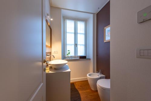 a bathroom with a sink and a toilet and a window at Casa Rita, Charming House with pool, Asti in Asti