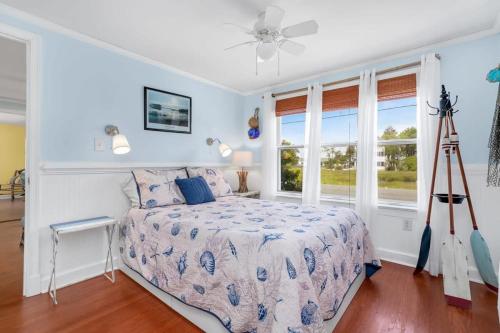 a bedroom with a bed and a large window at Cottage w Private Creek, Sunroom, Fire Pit, & WiFi in Chincoteague