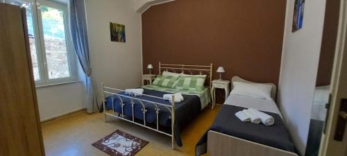 a small bedroom with two beds and a window at Mediterraneo in Scilla
