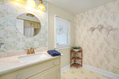 a bathroom with a sink and a mirror at Cottage w Private Creek, Sunroom, Fire Pit, & WiFi in Chincoteague