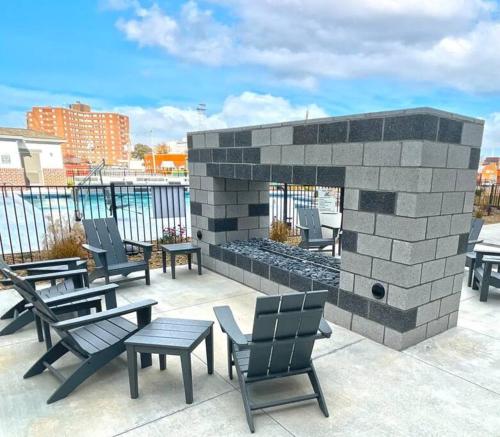 a brick fireplace with chairs and tables on a patio at Downtown Augusta luxury 2bed apt in Augusta