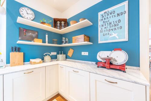 a kitchen with white cabinets and a blue wall at Casa Rita, Charming House with pool, Asti in Asti