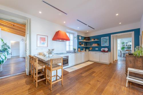 a large kitchen with blue walls and wooden floors at Casa Rita, Charming House with pool, Asti in Asti