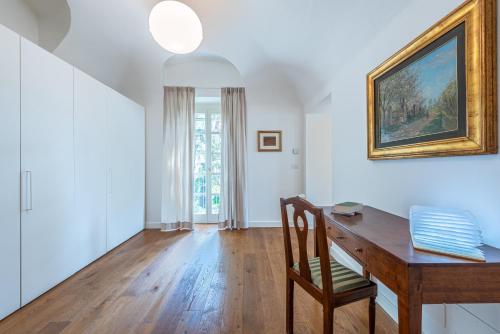 a home office with a wooden desk and a painting on the wall at Casa Rita, Charming House with pool, Asti in Asti