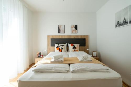 - une chambre avec un grand lit et 2 serviettes dans l'établissement HM • Sunny 1BR Home with Balcony, à Vienne