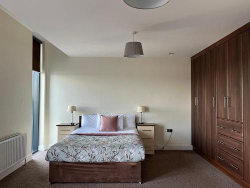 1 dormitorio con 1 cama con 2 mesitas de noche y 1 cama sidx sidx sidx sidx en The Western Citypoint Apartments, en Galway