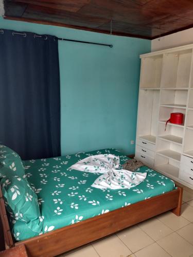 雅溫德的住宿－Appartement biteng，一间卧室设有一张床和蓝色的墙壁