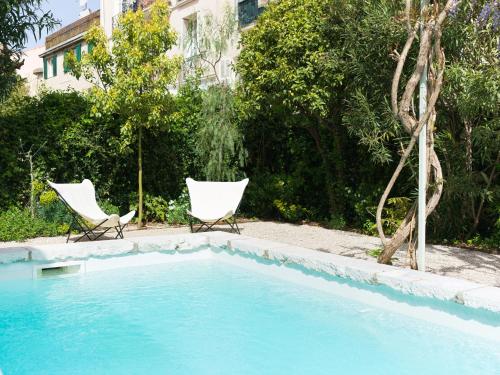 deux chaises assises à côté d'une piscine dans l'établissement Le 6 _ Appartement d'exception, à Vence
