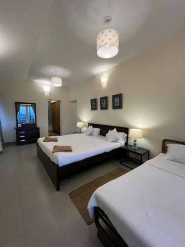 a bedroom with two beds and two tables and two lamps at Sunset Villa in Coonoor
