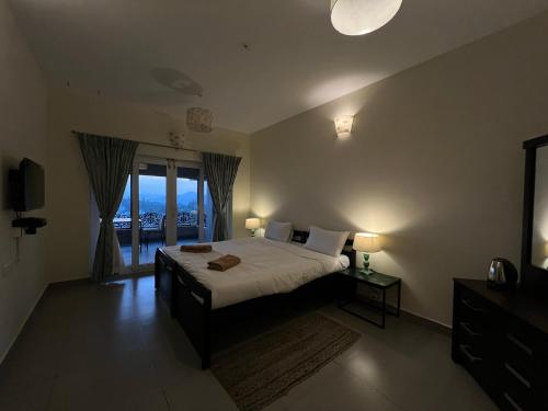 a bedroom with a large bed and a balcony at Sunset Villa in Coonoor