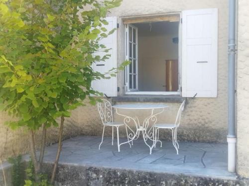 einen Tisch und zwei Stühle vor einem Fenster in der Unterkunft la Villa Charme et Confort in Chamaret