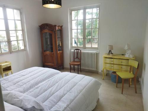 Schlafzimmer mit einem großen weißen Bett und einem Schreibtisch in der Unterkunft la Villa Charme et Confort in Chamaret