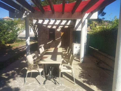 eine Terrasse mit einem Tisch und Stühlen unter einer Pergola in der Unterkunft la Villa Charme et Confort in Chamaret