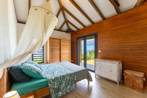 a bedroom with a bed and a window at Calypso Bay in Bouillante