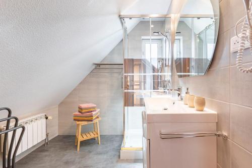 a bathroom with a sink and a mirror at Les Glycines du Sommerberg in Niedermorschwihr