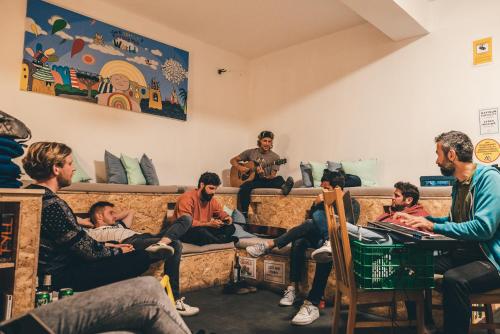 un grupo de personas sentadas en un sofá en La Ventana Azul Surf Hostel, en Las Palmas de Gran Canaria
