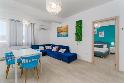 uma sala de estar com um sofá azul e uma mesa em Curaçao Apartments - Building Stefan em Mamaia Nord – Năvodari