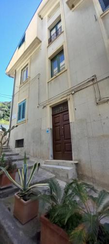 a building with a door and plants in front of it at Mediterraneo in Scilla