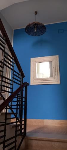 a blue wall with a window and a staircase at Mediterraneo in Scilla