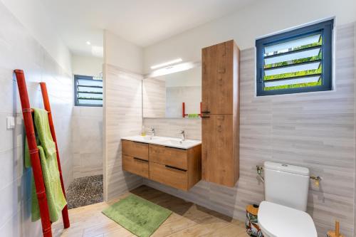 a bathroom with a sink and a toilet at Calypso Bay in Bouillante