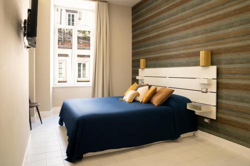 een slaapkamer met een blauw bed en een raam bij NapArt in Napels