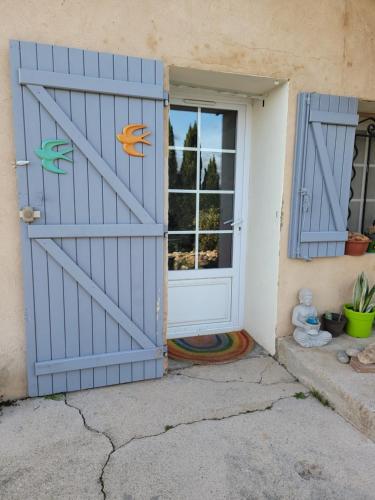 une porte menant à une maison avec des portes bleues dans l'établissement Cigaloun, à Moissac-Bellevue