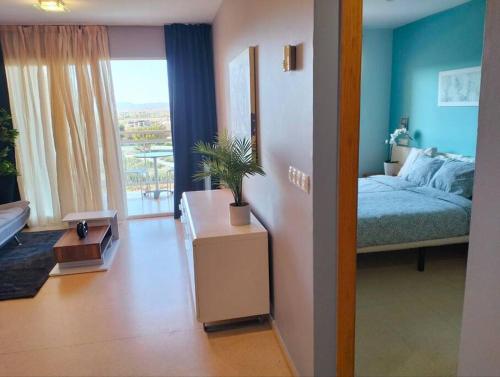 a living room with a bed and a table with a plant at Apartamento Moderno en Guardamar in Guardamar del Segura