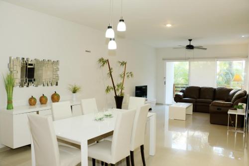 Luxury Coral Dream في بلايا ديل كارمن: غرفة طعام وغرفة معيشة مع طاولة وكراسي بيضاء