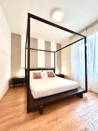 a bedroom with a black canopy bed with white sheets at Fiera Maison in Verona