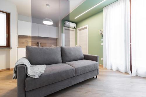 a living room with a gray couch in a room at Il Chiostro di Santa Caterina in Vimercate