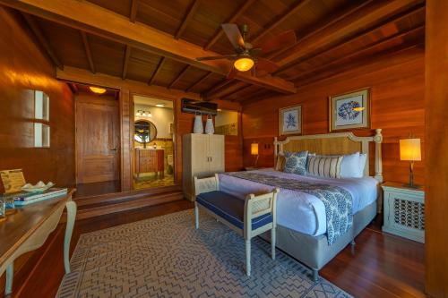 1 dormitorio con 1 cama, mesa y nevera en Playa Cativo Lodge, en Esquinas