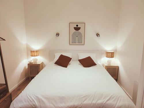 een slaapkamer met een groot wit bed met 2 lampen bij Au rue du gaz YourHostHelper in Rodez