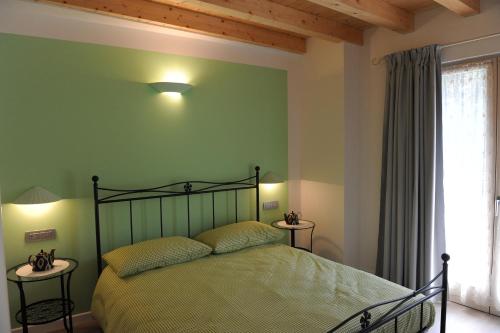 een slaapkamer met een bed met groene muren en een raam bij B&B La Teiera in Boario Terme