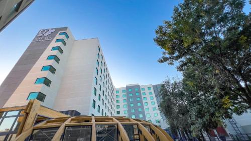 a tall building with a wooden structure in front of it at Hotel Diego de Almagro Pudahuel Aeropuerto in Santiago