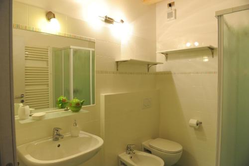 a bathroom with a sink and a toilet and a mirror at B&B La Teiera in Boario Terme