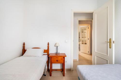 a bedroom with two beds and a table with a lamp at Centric and spacious flat with free car park in Seville