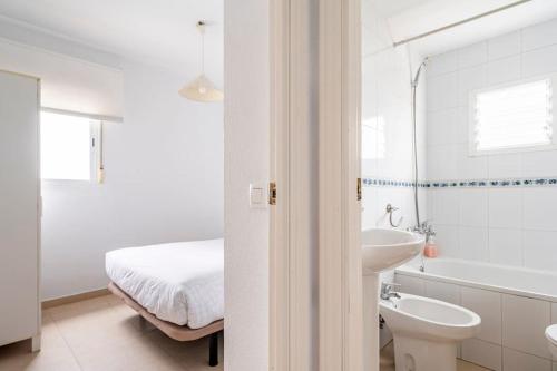 a white bathroom with a bed and a sink at Centric and spacious flat with free car park in Seville
